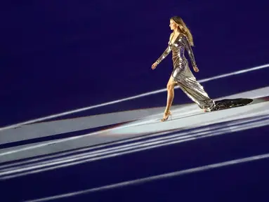 Model seksi asal Brazil Gisele Bundchen berjalan di atas panggung dengan gaun mengkilapnya saat mengambil bagian dalam upacara pembukaan Olimpiade Rio 2016, Rio de Janeiro, Brasil, (5/8). (REUTERS / Mike Blake)
