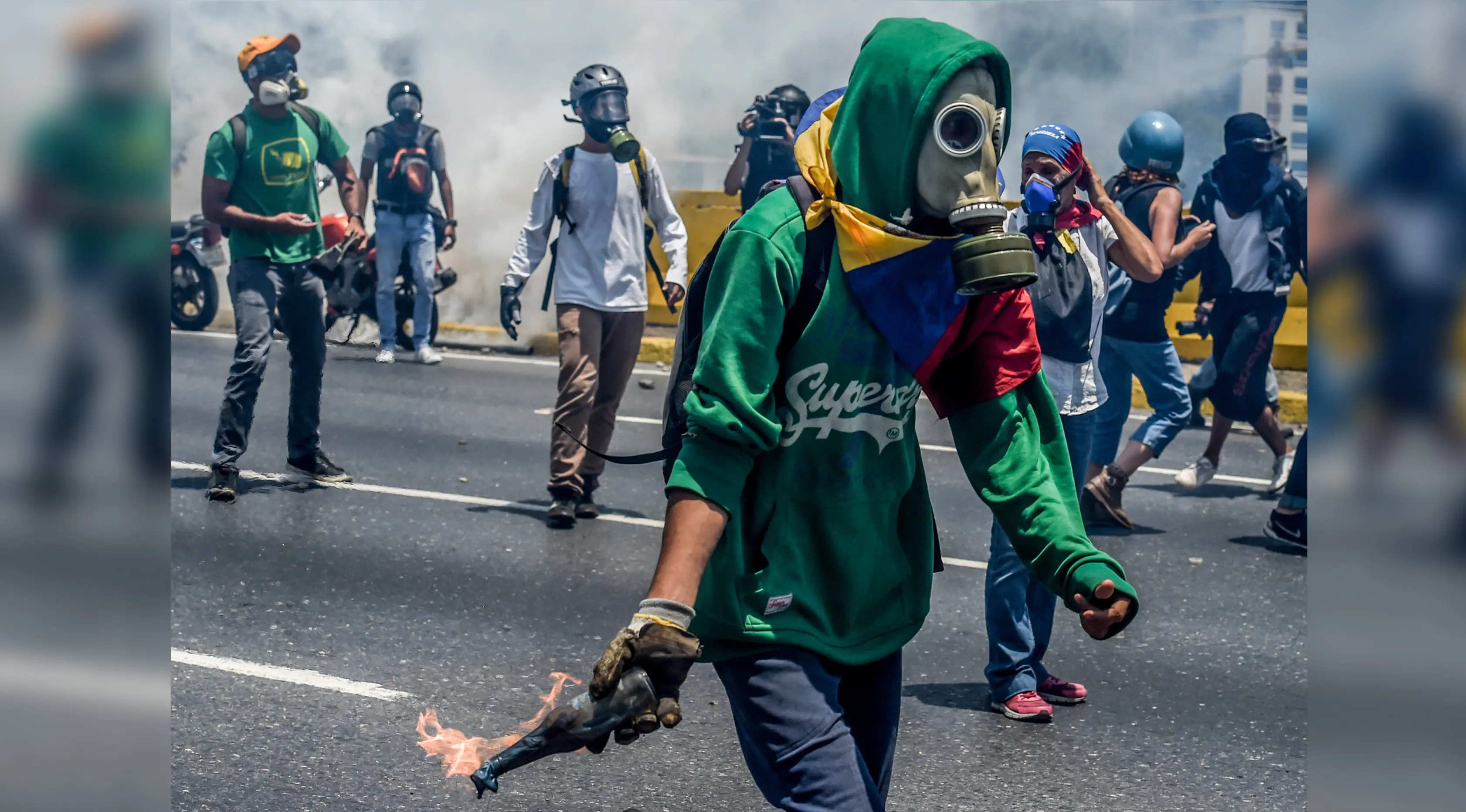 Demonstran bersenjatakan bom molotov saat demonstrasi menentang Presiden Nicolas Maduro di Caracas,  Venezuela, Rabu (26/4). Hingga kini, bentrokan antara demonstran dan polisi telah menyebabkan 26 orang tewas. (AFP PHOTO) 