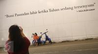 Seorang anak kecil berpose di depan mural bertema Kota Bandung di Jalan Asia Afrika, Bandung, Jawa Barat, Selasa (5/7). Dua buah mural tersebut menjadi lokasi favorit bagi warga dan wisatawan di Bandung untuk berfoto. (Liputan6.com/Immanuel Antonius)