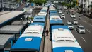 Seorang warga melewati Bus Transjakarta mogok kerja mengantarkan penumpang di Halte Harmoni, Jakarta (12/6). Akibat aksi mogok kerja tersebut, operasional bus Transjakarta menjadi terganggu. (Liputan6.com/Gempur M Surya)