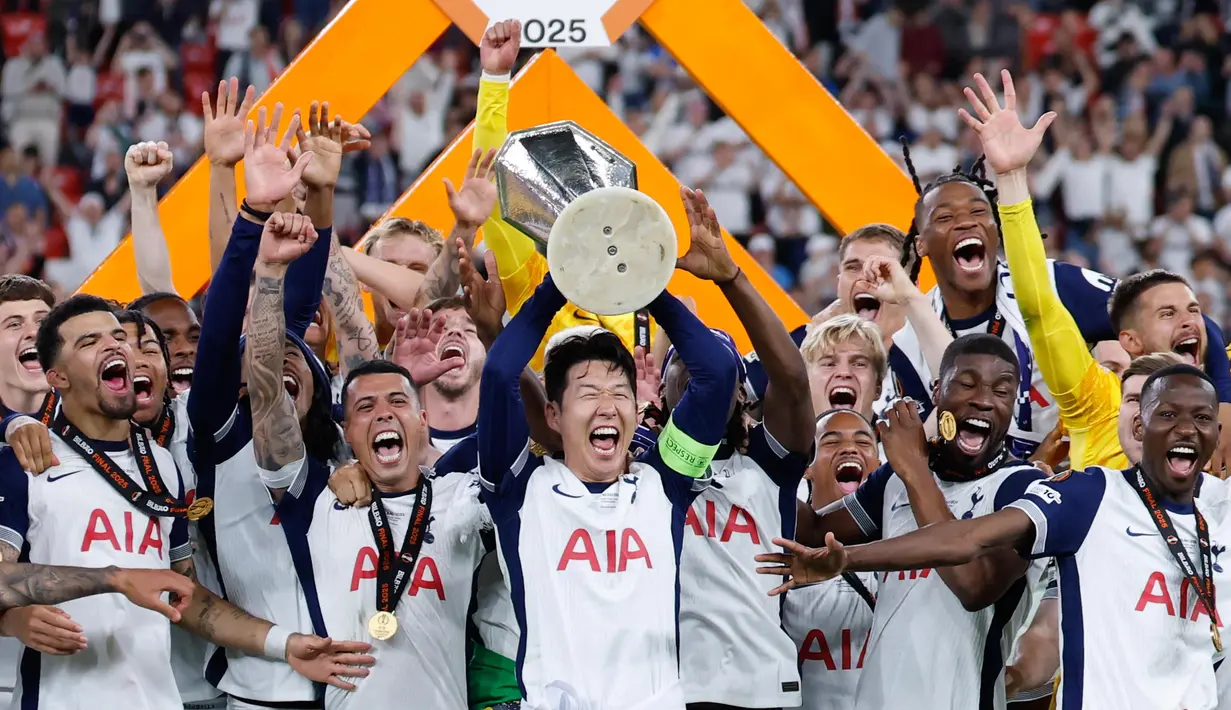 Pemain depan Tottenham Hotspur asal Korea Selatan, Son Heung-min mengangkat trofi Liga Europa saat merayakan kemenangan bersama rekan setimnya usai pertandingan final melawan Manchester United di stadion San Mames, Bilbao, pada 21 Mei 2025 waktu setempat atau Kamis (22/5) dini hari WIB. (Thomas COEX/AFP)