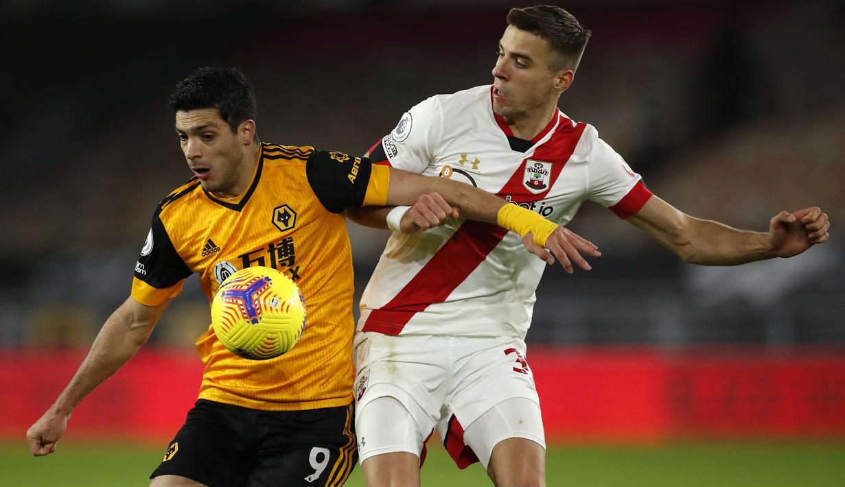 Striker Wolverhampton Wanderers, Raul Jimenez, berebut bola dengan bek Southampton, Jan Bednarek, pada laga lanjutan Liga Inggris di Molineux Stadium, Selasa (24/11/2020) dini hari WIB. Wolverhampton imbang 1-1 menghadapi Southampton. (AFP/Andrew Boyers/pool)