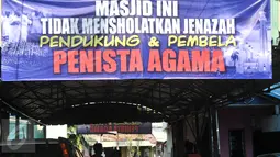 Spanduk yang terpasang di halaman Masjid Al-Jihad berada di Jalan BB 9A, Karet Setiabudi, Jakarta Selatan, Minggu (26/2). Menurut pihak setempat spanduk tersebut juga sebagai bentuk aksi pembelaan terhadap agama. (Liputan6.com/Yoppy Renato)