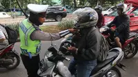 Polisi memeriksa kelengkapan pengendara motor saat Operasi Keselamatan Jaya 2018  di Jalan Letjen Suprapto, Jakarta, Senin (5/3). Dalam operasi ini berfokus pada berbagai pelanggaran, seperti penggunaan ponsel saat mengemudi. (Liputan6.com/Arya Manggala)