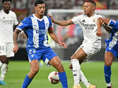 Penyerang Real Madrid, Kylian Mbappe (tengah) berebut bola dengan Alvaro Mourino dan Carlos Benavidez (Alaves) selama pertandingan sepak bola Liga Spanyol di stadion Santiago Bernabeu, Madrid, Selasa 24 September 2024 atau Rabu (25/9/2024) dini hari WIB. (JAVIER SORIANO/AFP)