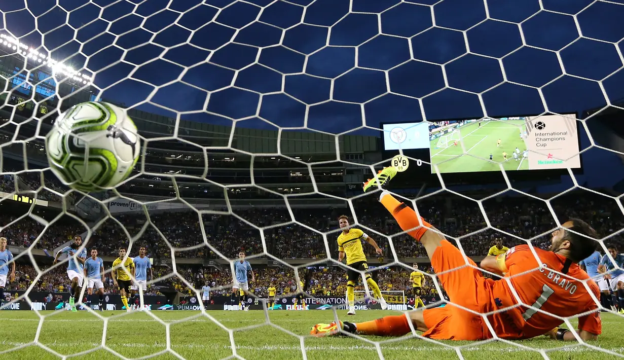 Claudio Bravo gagal mengahalau tendangan penalti Mario Gotze pada laga International Champions Cup 2018 di Soldier Field, Chicago, (20/7/2018), waktu setempat. Drtmund menang 1-0. (Elsa/Getty Images/AFP)