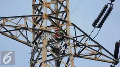 Seorang pria berada di atas menara sutet di kawasan Pasar Senen, Jakarta, Selasa (27/9). Pria nekat tersebut berencana memasang bendera merah putih dengan sebuah kalimat berisi permintaan untuk menghukum oknum Dandim. (Liputan6.com/Gempur M Surya)