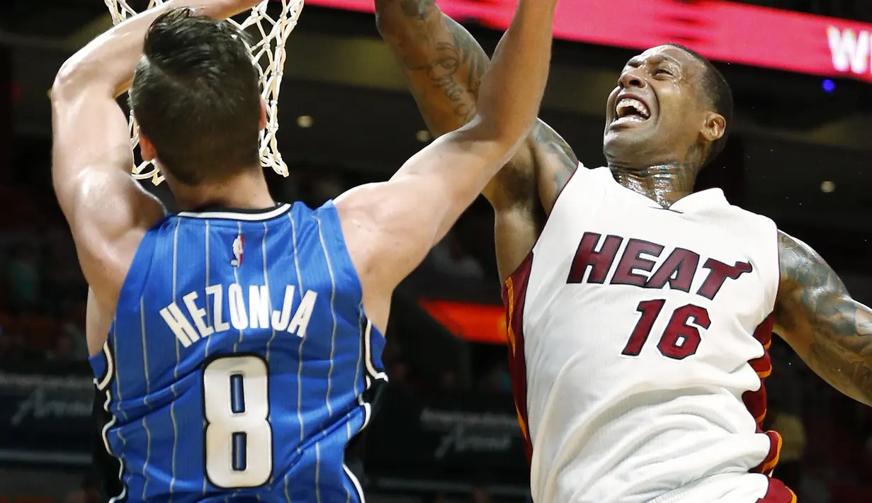 Pemain Miami Heat, James Johnson #16 melakukan blok atas tembakan pemain Orlando Magic, Mario Hezonja #8  pada laga NBA preseason basketball game, di Miami (19/10/2016) WIB. (AP/Wilfredo Lee)