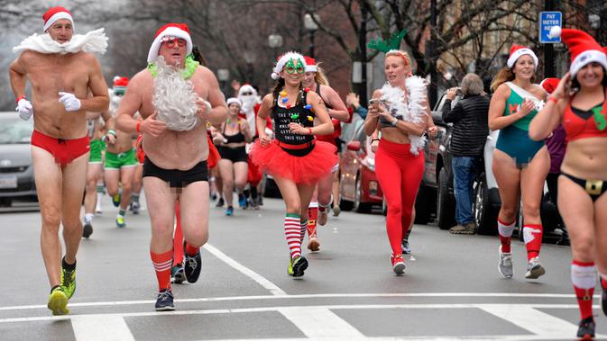 Pelari berjalan menyusuri Newbury Street selama Santa Speedo Run di Boston, Massachusetts, Sabtu (14/12/2019). Speedo Run adalah perlombaan lari menjelang Natal dengan peserta pria hanya menggenakan celana dalam dan wanita memakai bikini beserta topi ala Sinterklas. (Joseph Prezioso/AFP)