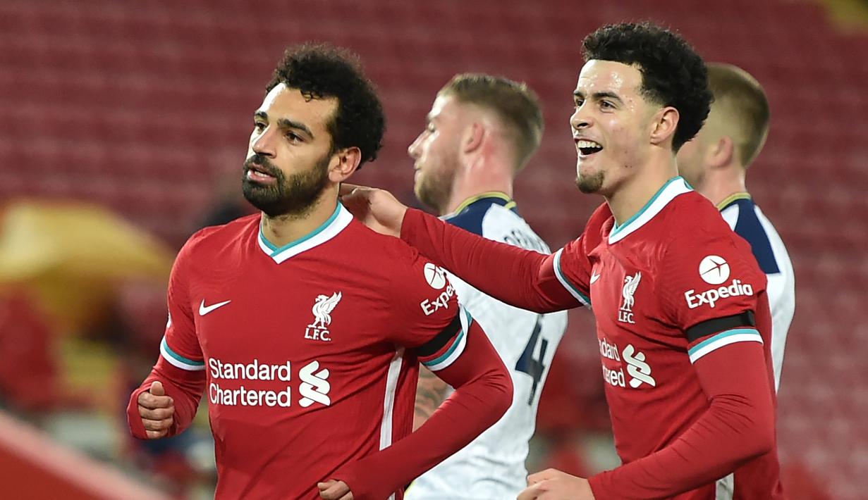 Gelandang Liverpool, Mohamed Salah (kiri) melakukan selebrasi bersama Curtis Jones, usai mencetak gol pertama timnya ke gawang Tottenham Hotspur dalam laga lanjutan Liga Inggris 2020/21 pekan ke-13 di Anfield Stadium, Rabu (16/12/2020). Liverpool menang 2-1 atas Tottenham. (AFP/Peter Powell/Pool)