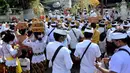 Umat Hindu membawa sesaji saat akan berdoa pada perayaan Hari Raya Kuningan di Pura Sakenan, Pulau Serangan, Denpasar, Bali, Sabtu (20/11/2021). Kuningan merupakan hari terakhir perayaan Galungan yang diyakini sebagai hari naiknya roh suci leluhur kembali ke surga. (Sonny TUMBELAKA/AFP)