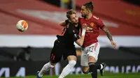 Bek Manchester United, Alex Telles (kanan) berebut bola dengan striker Real Sociedad, Adnan Januzaj dalam laga leg kedua babak 32 Besar Liga Europa 2020/21 di Old Trafford Stadium, Kamis (25/2/2021). Manchester United bermain imbang 0-0 dengan Real Sociedad. (AFP/Oli Scarff)