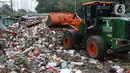 Petugas mengoperasikan alat berat untuk memindahkan sampah di Tempat Pembuangan Sementara Kalibata, Jumat (10/4/2020). Kadis Lingkungan Hidup DKI Jakarta, Andono Warih mengatakan terjadi penurunan tonase sampah rata-rata 620 ton per hari selama penerapan WFH. (Liputan6.com/Helmi Fithriansyah)
