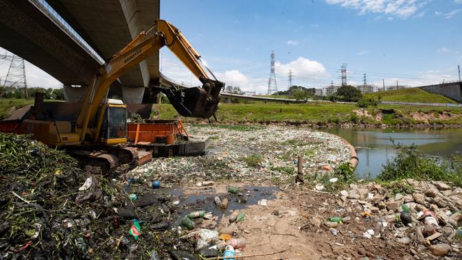 Ekskavator mengangkut sampah dari tepian Sungai Pinheiros di Sao Paulo, 22 Oktober 2020. Akibat pembuangan limbah domestik dan padat selama bertahun-tahun, pemerintah Sao Paulo kembali mencoba membersihkan Sungai Pinheiros yang dianggap sebagai salah satu paling tercemar di Brasil. (AP/Andre Penner)