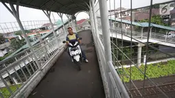 Pengendara sepeda motor melewati Jembatan Penyeberangan Orang (JPO) di kawasan Pasar Minggu, Jakarta, Selasa (17/10). JPO yang merupakan hak para pejalan kaki justru digunakan pemotor untuk menyeberang. (Liputan6.com/Immanuel Antonius)
