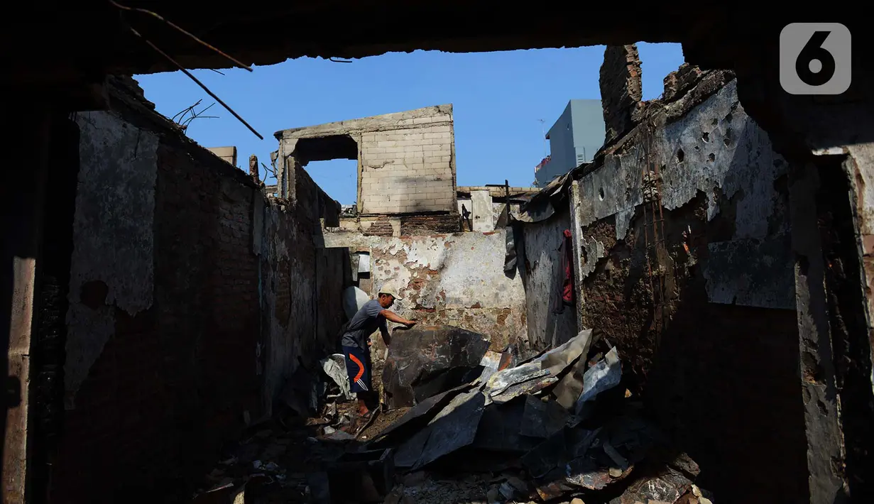 Warga membesihkan sisa barang dalam rumah yang terbakar di RW 02, Kelurahan Bidari Cina, Jakarta, Selasa (22/10/2019). Tidak ada korban jiwa akibat kebakaran tersebut yang menghanguskan 56 rumah tersebut. (merdeka.com/Imam Buhori)