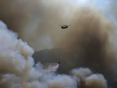 Sebuah helikopter berpartisipasi dalam operasi pemadaman kebakaran hutan di Koycegiz, Mugla, Turki, Senin (9/8/2021). Kebakaran hutan yang terjadi di tengah gelombang panas ganas telah berkobar selama berhari-hari di lebih dari setengah provinsi Turki. (AP Photo/Emre Tazegul)