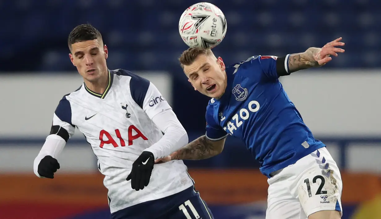 Gelandang Tottenham Hotspur, Erik Lamela (kiri) berebut bola dengan bek Everton, Lucas Digne pada babak 16 besar Piala FA di Goodison Park, Inggris, Kamis (11/2/2021). Everton membutuhkan babak perpanjangan waktu 2x15 menit untuk mengalahkan Tottenham. (AFP/Pool/Clive Brunskill)