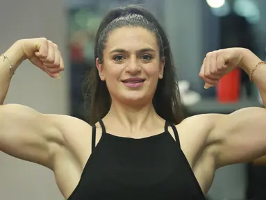 Binaragawan Yordania, Dana Sombouloglu menunjukkan ototnya selama sesi latihan di gym di ibukota Amman, pada 29 Januari 2020. Perempuan 26 tahun ini memiliki tekad kuat untuk membuktikan bahwa perempuan Yordania bisa jadi binaragawan. (AFP/Khalil Mazraawi)