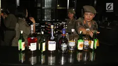Petugas Satpol PP wanita mengamankan sejumlah botol minuman keras di Sense Karaoke, Mangga Dua Square, Jakarta, Kamis (19/4). Pemprov DKI Jakarta resmi menutup Sense Karaoke karena melanggar peraturan. (Liputan6.com/Arya Manggala)