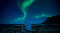 Seseorang menonton fenomena alam Aurora Borealis atau Northern Lights di Unstad, lingkaran Arktik, Norwegia, Sabtu (3/3). Aurora menampilkan banyak warna, tapi yang sering muncul adalah hijau muda dan pink. (Olivier MORIN/AFP)