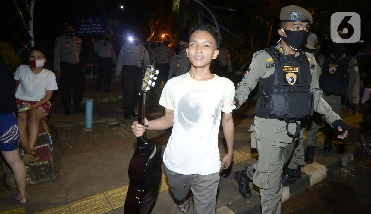 Petugas melakukan Operasi Yustisi mencegah penularan Covid-19 di Taman Perdamaian, Tangerang Selatan, Banten, Rabu (23/9/2020). Sebagai efek jera, warga yang tidak mengenakan masker diberi sanksi sosial berupa membersihkan toilet, menyapu, push up, dan denda Rp 50 ribu. (merdeka.com/Dwi Narwoko)
