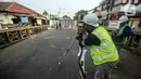 Pekerja melakukan pengukuran saat menyelesaikan proyek revitalisasi Jembatan Cibubur, Jakarta, Selasa (2/8/2022). Revitalisasi ditargetkan selesai pada 6 November 2022. (Liputan6.com/Faizal Fanani)