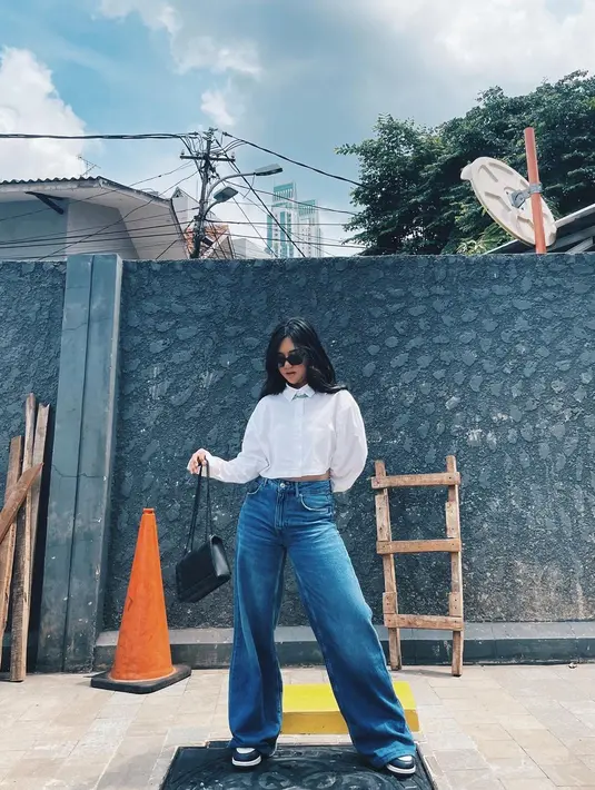 Kali ini Ziva Magnolya memadukan denim dan kemeja putih. Sedikit boyish dari boyfriend jeans dan sneakers berpadu dengan cropped long sleeve shirt dan shoulder bag berwarna hitam. [instagram/zivamagnolya]
