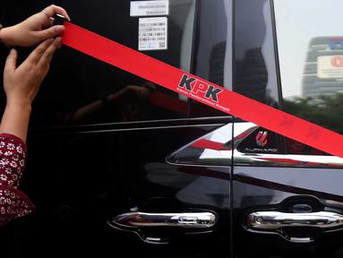 Petugas Komisi Pemberantasan Korupsi (KPK) memasang garis pembatas di samping mobil Alphard hasil sitaan penggeledahan rumah dinas Wakil Menteri Ketenagakerjaan (Wamenaker) Immanuel Ebenezer di kawasan Pancoran, Jakarta Selatan, Selasa (26/8/2025). (Liputan6.com/Helmi Fithriansyah)