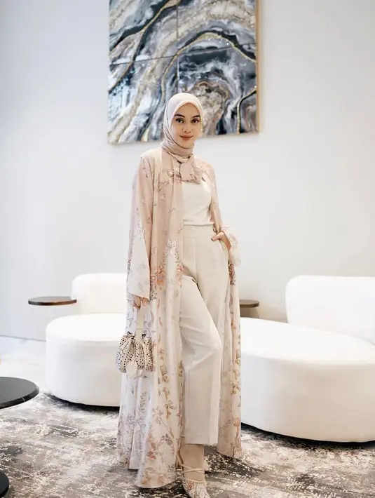 Kulot dipadukan dengan long outer motif floral warna nude dan putih bikin penampilanmu lebih anggun. (Instagram/tiqasya).