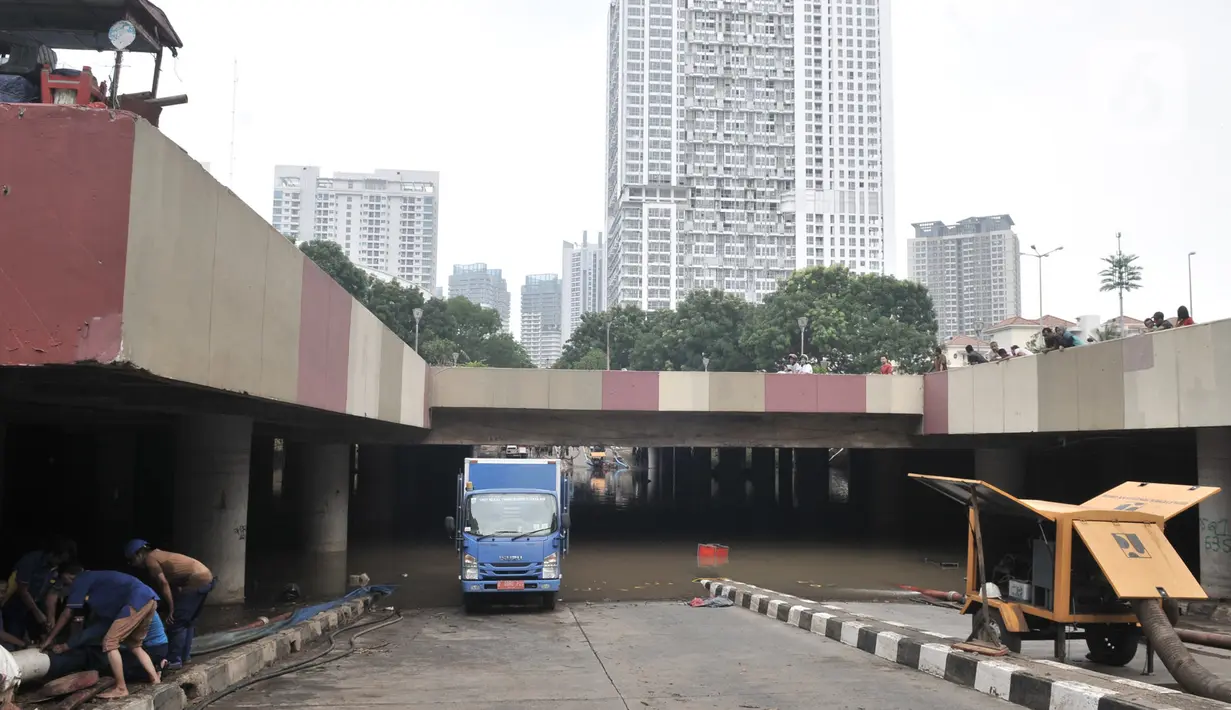 Petugas mengerahkan pompa untuk menyedot banjir di Underpass Kemayoran, Jakarta, Minggu (26/1/2020). Banjir yang terjadi sejak Jumat (24/1) lalu hingga kini belum surut. (merdeka.com/Iqbal S Nugroho)