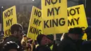 Para pengunjuk rasa memegang plakat "Not My King". (HENRY NICHOLLS/AFP)
