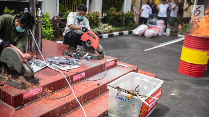 Petugas memusnahkan barang bukti berupa senjata api di lapangan Kejaksaan Negeri Jakarta Barat, Selasa (11/12). Pemusnahan barang bukti merupakan bentuk keseriusan penegak hukum dalam pengentasan kasus-kasus kejahatan. (Liputan6.com/Faizal Fanani)