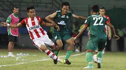 Pemain Persepam Madura United, Rossi Noprihanis (kiri) dihadang pemain PSS Sleman, Wawan Widiantoro pada laga Piala Kemerdekaan di Stadion Wilis, Madiun, Sabtu (15/08/2015). Persepam berhasil taklukan PSS 2-0. (Bola.com/Robby Firly)