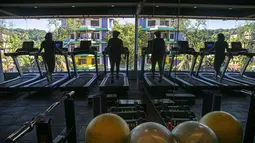 Sejumlah wanita India berolahraga di gym yang dibuka kembali setelah lockdown di Gauhati, India, Rabu, (5/8/2020). India memiliki jumlah virus coronavirus tertinggi ketiga di dunia setelah Amerika Serikat dan Brasil. (AP Photo/Anupam Nath)