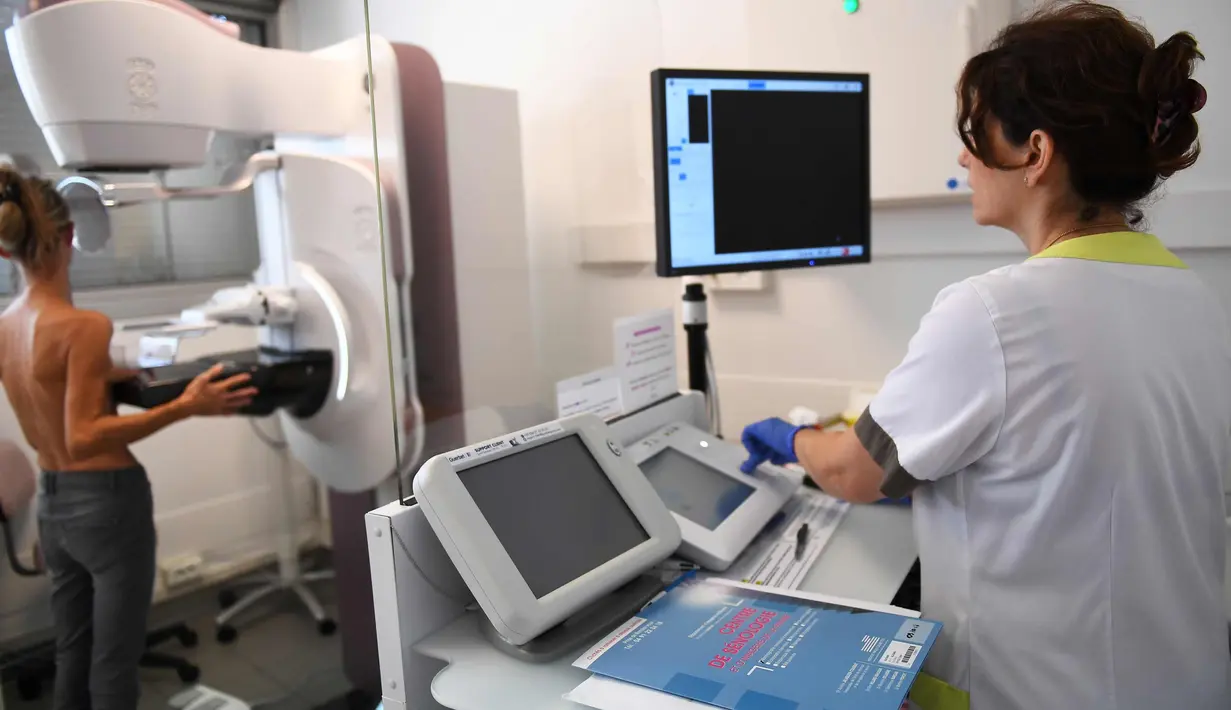 Dokter memeriksa payudara pasien dengan mammogram di pusat regional kanker di institut Paoli-Calmette, (9/10). mammogram menggunakan radiasi ion untuk menghasilkan gambar. (AFP Photo/Anne Christine Poujoulat)