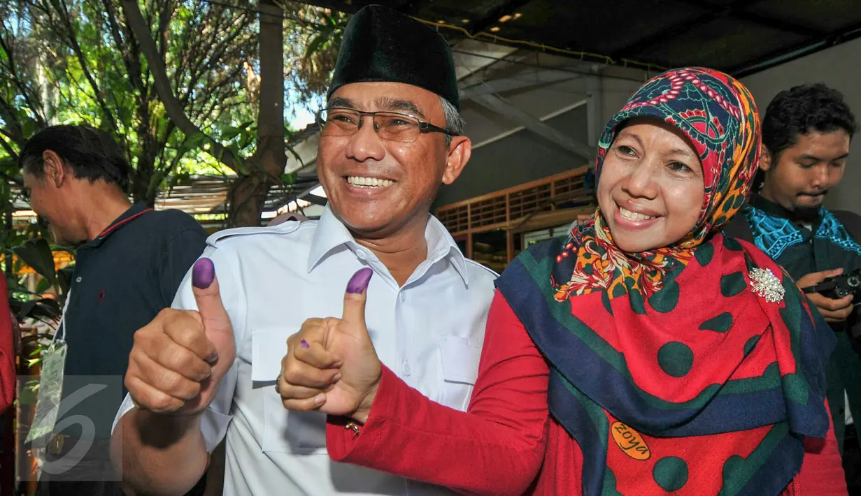 Mohammad Idris dan istri usai melakukan pencoblosan di TPS 077 di Perum Pondok Duta, Sukmajaya, Depok, (9/12). Idris akan bersaing dengan pasangan nomor urut satu yaitu Dimas Oky Nugroho dan Babai Suhaimi. (Liputan6.com/Yoppy Renato)