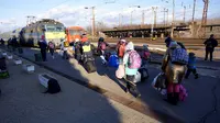 Orang-orang membawa barang-barang mereka saat berjalan untuk mengejar kereta api ke Budapest di stasiun di Zahony, Hungaria, 8 Maret 2022. PBB mengatakan, serangan gencar Rusia telah memaksa lebih dari 2 juta orang meninggalkan Ukraina. (AP Photo/Darko Vojinovic)