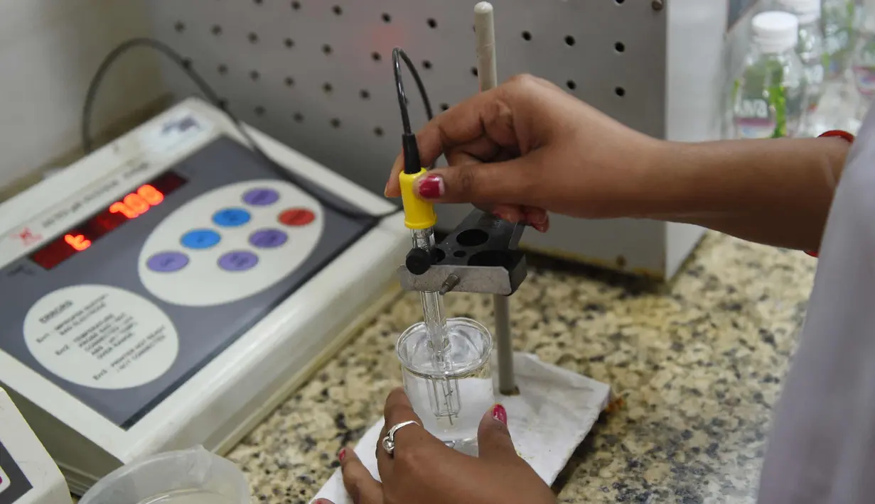 Seorang asisten kimia laboratorium memeriksa kualitas air di pabrik air mineral alami Aava di Ahmedabad, India (19/3). Hari Air Sedunia jatuh pada tanggal 22 Maret. (AFP Photo/Sam Panthaky)