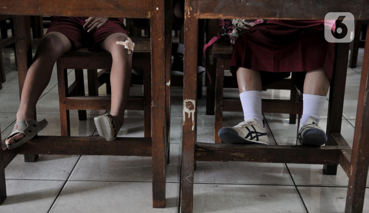 Siswa mengenakan sandal saat mengikuti kegiatan belajar di SDN Bukit Duri 11, Jakarta, Senin (6/1/2020). Sebagian siswa di sekolah ini mengenakan pakaian bebas dan sandal akibat seragam serta sepatu mereka hilang terbawa arus banjir. (merdeka.com/Iqbal S. Nugroho)