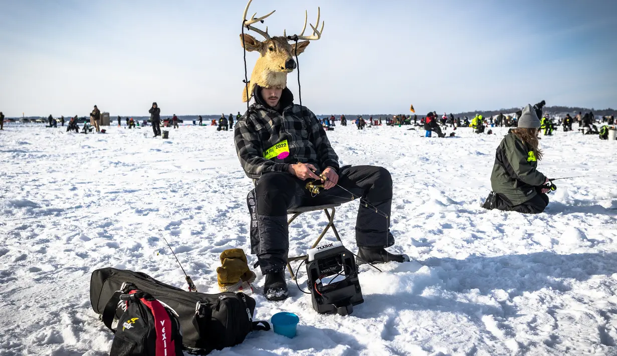 Tucker Welch memancing ikan dalam acara Brainerd Jaycees Ice Fishing Extravaganza tahunan ke-32 di Gull Lake's Hole di Teluk Day, Minnesota pada 29 Januari 2022. Hampir 10.000 pemancing dari Minnesota dan negara bagian lain menghadiri kontes memancing es amal terbesar di dunia. (Kerem Yucel/AFP)