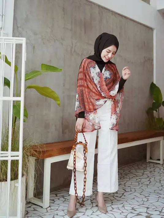 Untuk outfit semi formal, padukan wrap cardigan bernuansa etnik dengan kulot putih dan heels. (Instagram/emyaghnia).