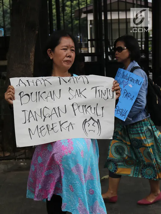 Kaum ibu yang tergabung dalam Emak-Emak Indonesia membentangkan poster saat aksi di depan Gedung Polda Metro Jaya, Jakarta, Minggu (29/9/2019). Mereka juga menuntut Presiden Jokowi untuk menghentikan intimidasi serta kriminalisasi pejuang demokrasi. (Liputan6.com/Herman Zakharia)
