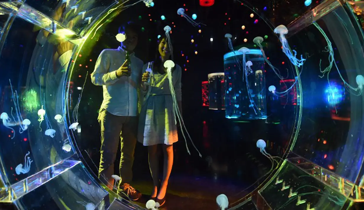 Pengunjung melihat Kawanan ubur-ubur di dalam akuarium Epson Aqua Park Shinagawa, Tokyo, Jepang (6/7/2015). Terdapat Ubur-ubur dengan berbagai bentuk saat pembukaan Epson Aqua Park Shinagawa. (AFP PHOTO/TOSHIFUMI KITAMURA)
