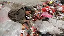 Seorang bocah laki-laki duduk di antara tumpukan sampah di sebuah tempat pembuangan akhir (TPA) di pinggiran Sanaa, Yaman, Rabu (16/11). Setiap hari para bocah di daerah tersebut mengumpulkan sampah untuk didaur ulang. (REUTERS/Mohamed al-Sayaghi)