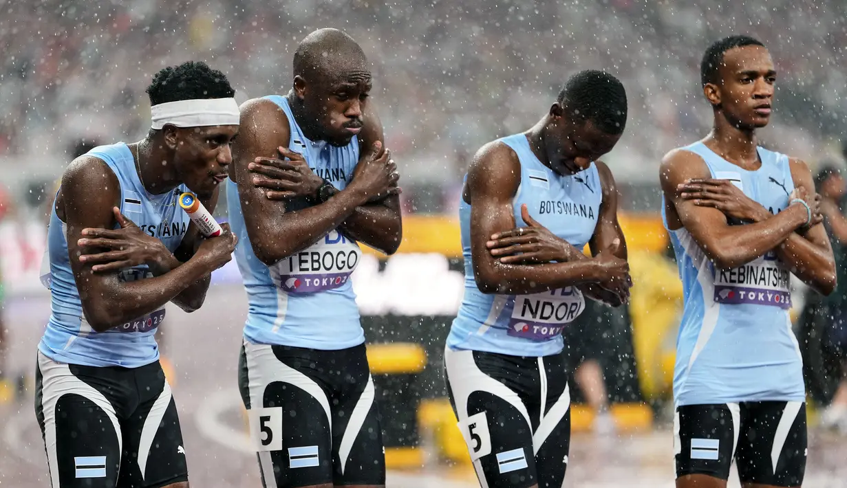 Tim Botswana terlihat kedinginan saat hujan sebelum dimulainya nomor estafet 4x400 meter putra dalam ajang Kejuaraan Dunia Atletik 2025 di Tokyo, Jepang, Minggu (21/09/2025). (AP Photo/Eugene Hoshiko)