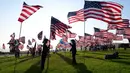 Orang-orang membantu pengibaran bendera AS untuk peringatan 20 tahun serangan 9/11 di Pepperdine University di Malibu, California, Rabu (8/9/2021). Selama 14 tahun, universitas itu memperingati tragedi 11 September 2001 dengan mengibarkan sekitar 3.000 bendera Amerika. (Frederic J. BROWN/AFP)