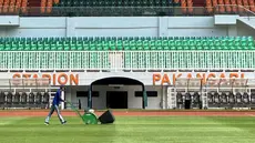 Seorang petugas melakukan perawatan rumput Stadion Pakansari, Cibinong, Kabupaten Bogor, Rabu (23/7/2026). Perawatan lapangan terus dilakukan menjelang Stadion Pakansari menjadi kandang Timnas Indonesia pada babak penyisihan Grup A Piala AFF 2026. Pengelola stadion melakukan treatment rumput sejak berakhirnya Pegadaian Championship 2025/2026 dengan pendampingan dari tim PSSI agar kondisi lapangan memenuhi standar untuk pertandingan internasional. (Bola.com/Muhammad Adi Yaksa)