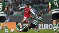 Pemain Arsenal, Reiss Nelson (tengah) berusaha melewati pemain Sporting CP pada laga leg pertama Liga Europa 2022/2023 di Jose Alvalade Stadium, Lisbon, Jumat (10/03/2023) dini hari WIB. Laga berakhir dengan skor imbang 2-2. (AP Photo/Armando Franca)