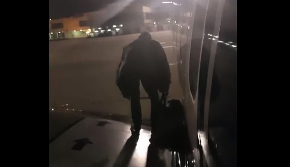 Seorang penumpang maskapai Ryanair keluar lewat pintu darurat di sayap pesawat di Bandara Malaga, Spanyol, Rabu (3/1). Pria berkebangsaan Polandia itu lalu santai saja duduk di pesawat, meletakkan tas di sampingnya. (Fernando Del Valle/AFP)